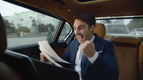 Happy-businessman-delighting-with-excellent-data-in-modern-car.-Man-in-car