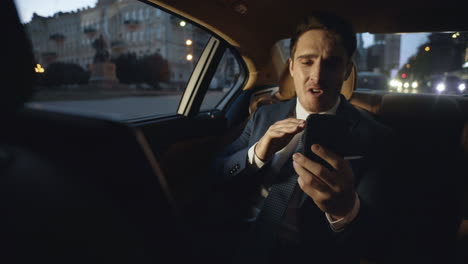 Angry-business-man-giving-instructions-in-video-chat-in-luxury-automobile.
