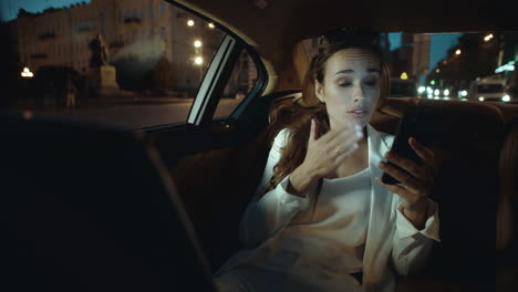 Anxious-business-lady-troubleshooting-relationship-on-video-chat-in-luxury-car.
