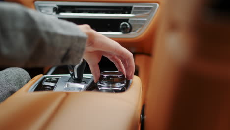Closeup-woman-hand-using-control-knob-in-car.-Female-using-car-joystick