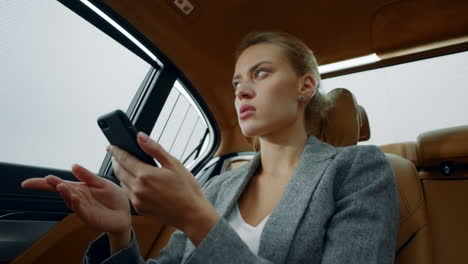 Portrait-of-woman-typing-letter-on-phone-at-luxury-car.-Girl-thinking-at-vehicle