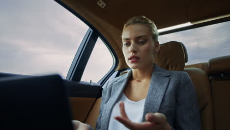 Angry-businesswoman-having-video-call-at-car.-Confident-woman-using-computer