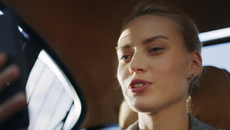 Portrait-of-businesswoman-talking-mobile-phone-at-car.-Girl-making-video-call