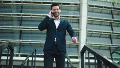 Businessman-walking-downstairs-at-street.-Man-using-mobile-phone-outdoors