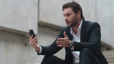 Business-man-talking-online-with-client-on-street.-Male-manager-using-smartphone