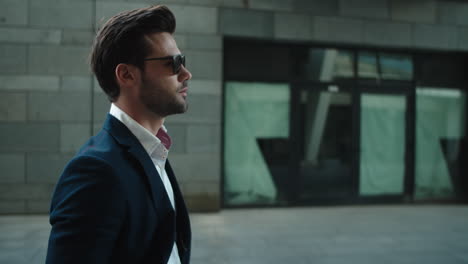 Portrait-man-wearing-sunglasses-at-street.-Man-turning-head-in-suit-outside