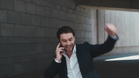 Businessman-talking-on-cellphone-in-city.-Male-professional-celebrating-success