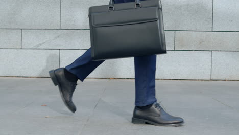 Businessman-legs-walking-on-city-street.-Worker-with-briefcase-going-for-work