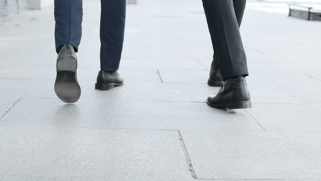 Businessmen-legs-walking-on-urban-street-together.-Colleagues-going-for-work