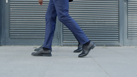 Business-men-walking-on-pavement-outside.Businessmen-taking-walk-on-urban-street