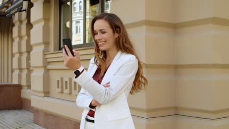 Erfolgreiche-Geschäftsfrau,-Die-Draußen-Einen-Videoanruf-Auf-Dem-Mobiltelefon-Führt