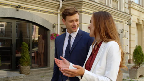 Cheerful-business-man-and-woman-talking-together-outdoors.