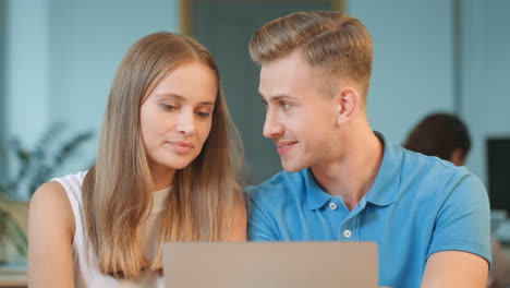 Happy-couple-discussing-project-at-coworking.-Closeup-guy-flirting-with-girl