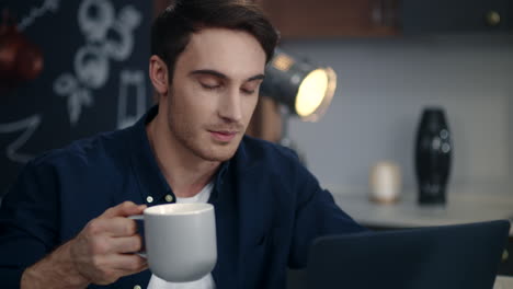 Happy-man-having-video-call-on-laptop-at-home.-Business-man-drinking-coffee