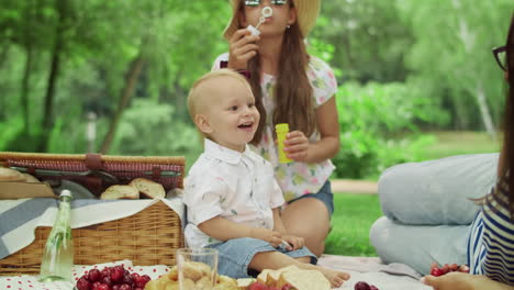 Family-spending-time-together-in-park.-Mother-and-son-holding-cherries-in-hands