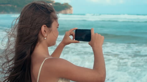 Joyful-girl-enjoying-landscape-at-seashore.-Teenager-using-cellphone-at-beach.