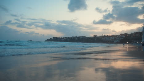 Waves-rolling-onto-seaside.-Unrecognizable-people-spending-morning-at-coastline.