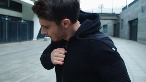 Closeup-serious-man-practicing-box-in-city-street.-Handsome-man-boxing-outside