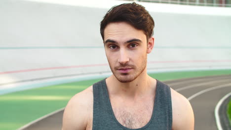 Closeup-athlete-man-smiling-on-track.-Portrait-of-runner-standing-on-track