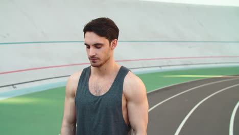 Portrait-of-sport-man-using-smart-watch-on-track.-Man-runner-checking-results