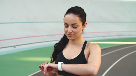 Retrato-De-Mujer-Mirando-Reloj-Inteligente.-Niña-Comprobando-El-Ritmo-Cardíaco-En-El-Campo-Deportivo