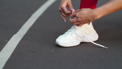 Nahaufnahme-Einer-Frau,-Die-Turnschuhe-Auf-Der-Strecke-Schnürt.-Fitness-Mädchen-Schnürt-Schuhe