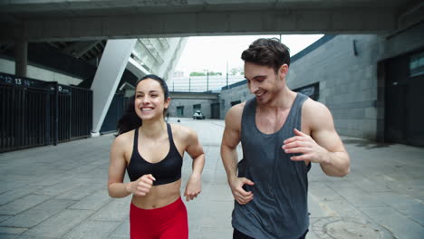 Close-up-cheerful-couple-running-outdoor.-Laughing-man-and-woman-training-run