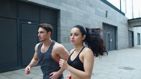 Closeup-sporty-couple-starting-run-outdoor.-Focused-couple-running-together