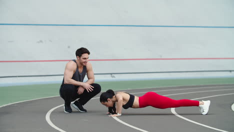 Couple-training-together-on-track.-Man-and-woman-warming-up-at-stadium