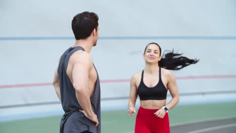 Couple-training-on-running-track.-Fit-instructor-training-girl-at-stadium