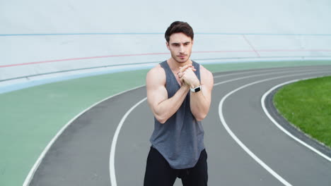 Runner-warming-up-at-modern-stadium.-Sport-man-stretching-at-stadium