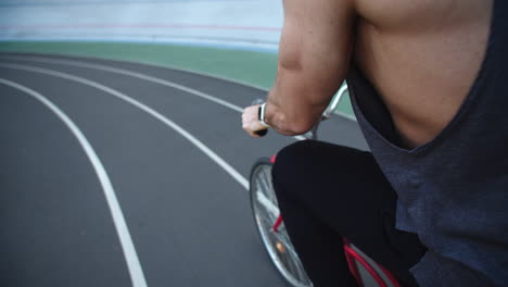 Cyclist-man-riding-bike-at-sport-stadium.-Back-view-bicyclist-riding-on-track