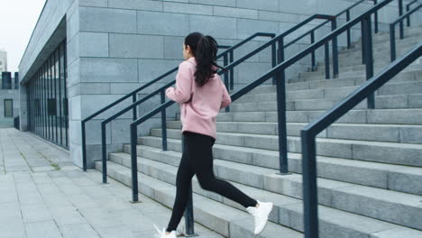 Fitness-Frau-Trainiert-Laufübung-Auf-Treppen.-Sportliches-Mädchen,-Das-Die-Treppe-Hinunterläuft
