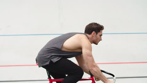 Cyclist-man-riding-bicycle-on-track-at-stadium.-Fitness-man-riding-bike