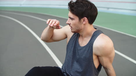 Portrait-of-tired-man-resting-after-running-workout-on-track.-Exhausted-runner