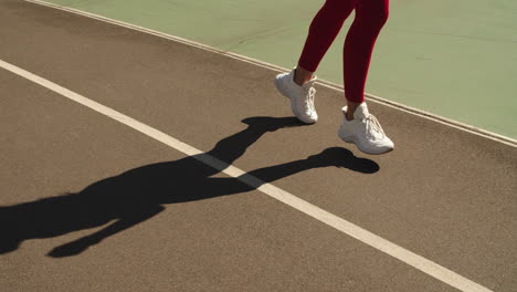 Primer-Plano-Pies-Femeninos-Corriendo-En-Zapatillas-De-Deporte-En-La-Pista.-Niña-Corriendo-Al-Aire-Libre-En-La-Pista