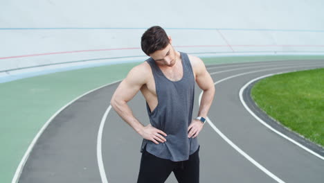 Male-warming-up-before-workout-at-track.-Man-starching-for-workout-at-stadium