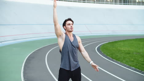 Corredor-Masculino-Calentando-Antes-De-Hacer-Ejercicio-En-La-Pista.-Hombre-En-Forma-Estirando-Las-Manos