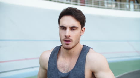 Portrait-of-sport-man-running-at-athletics-stadium.-Fitness-man-exercising