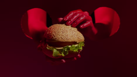 Close-up-of-tasty-cheeseburger-in-beautiful-woman-red-hands.-Appetite-burger.