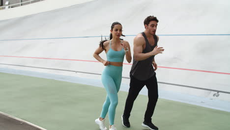 Pareja-De-Fitness-Entrenando-Juntos-En-El-Estadio-Moderno.-Pareja-Deportiva-Corriendo