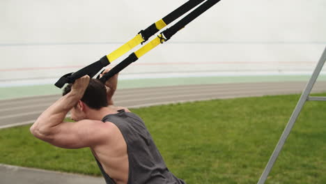 Hombre-Fitness-Haciendo-Ejercicio-Con-Cuerda-De-Suspensión-Trx-En-El-Estadio