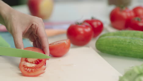 Nahaufnahme-Weiblicher-Hände,-Die-Rote-Tomaten-Mit-Einem-Messer-Schneiden.-Tomaten-Auf-Schneidebrett.