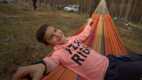 Teenager-boy-enjoying-time-in-swinging-hammock-in-forest.