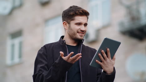 Surprised-man-looking-tablet-screen-outside.-Cheerful-guy-reading-message-tablet