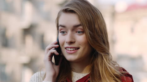 Smiling-girl-speaking-phone-on-street.-Happy-woman-using-phone-outdoors