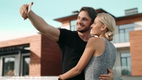 Smiling-couple-taking-selfie-outside-luxury-house.-Portrait-of-lovely-couple
