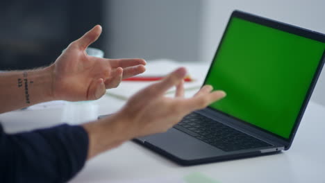 Closeup-businessman-talking-on-video-conference.-Man-looking-green-screen-laptop