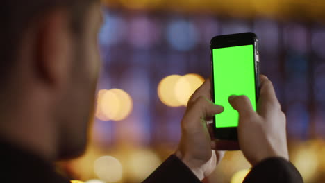 Man-hands-messaging-phone-green-screen.-Unrecognizable-guy-using-mock-up-phone.