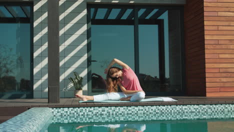 Young-woman-making-yoga-exercise-near-pool.-Business-woman-making-yoga-after-work
